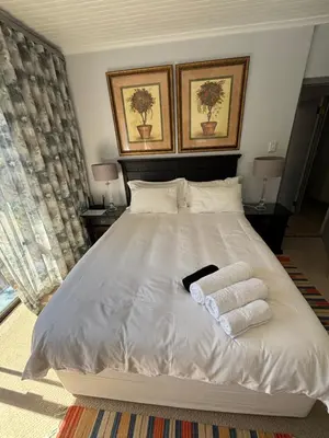 a bedroom with a white bed with two towels on it at Self Catering Luke Drive Onrus in Hermanus