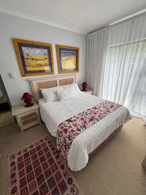 a bedroom with a bed and a large window at Self Catering Luke Drive Onrus in Hermanus