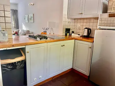 a kitchen with white cabinets and a white refrigerator at #Restyourcase in Stellenbosch