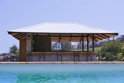 a gazebo next to a swimming pool at Ongegund Lodge in Somerset West