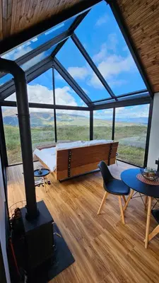 a room with a fireplace and a table and a chair at Little Acre Luxury Pods in Tulbagh