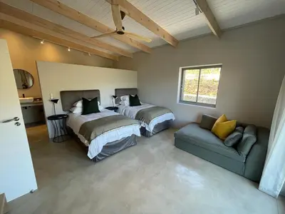 a bedroom with two beds and a couch in it at Windon vineyard farmhouse in Stellenbosch