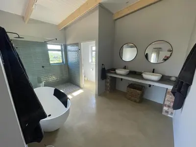 a bathroom with a large tub and two sinks and a bath tub at Windon vineyard farmhouse in Stellenbosch