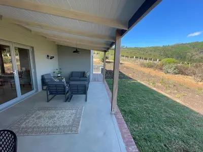 a patio with chairs and a table on a house at Windon vineyard farmhouse in Stellenbosch