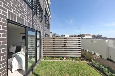 a fence on the side of a brick building at 002 Burmeister on Park- 2 minute walk from the beach in Cape Town