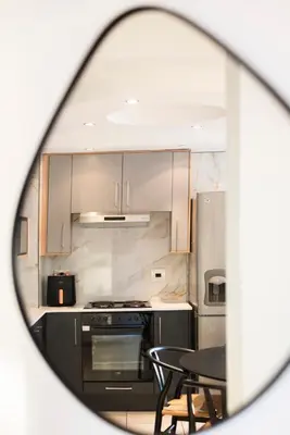 a kitchen with stainless steel appliances and a table and chairs at Stylish Sunlit Ocean View Oasis! in Cape Town