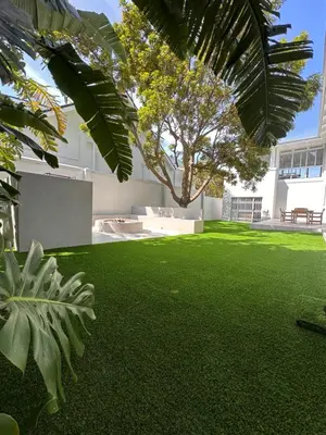 a yard with green grass and a tree and a building at Ocean Pearl Hermanus - 5 Bedrooms in Hermanus