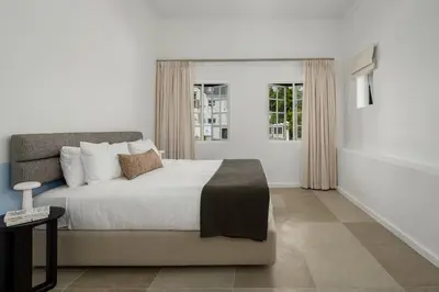 a bedroom with a large bed and a window at Neighbourgood Franschhoek in Franschhoek