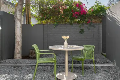 a table with two chairs and a vase on it at Neighbourgood Franschhoek in Franschhoek