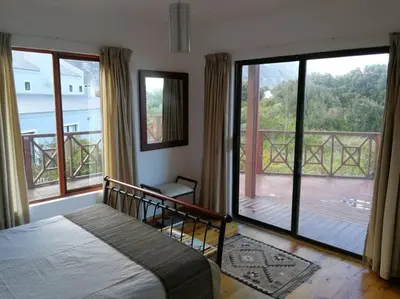 a bedroom with a bed and a view of a deck at Paradise Beach House in Clareport