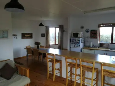 a kitchen with a large wooden table and chairs at Paradise Beach House in Clareport