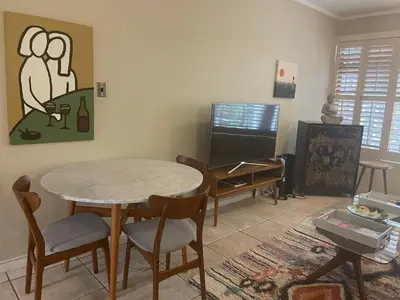 a living room with a table and chairs and a tv at Central Stellenbosch Apartment, Dorp Street in Stellenbosch