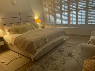 a bedroom with a large bed and a window at Central Stellenbosch Apartment, Dorp Street in Stellenbosch