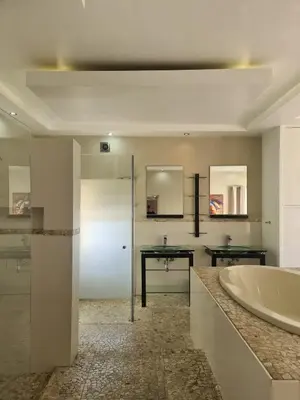 a bathroom with a large tub and a sink at Bikini Beach Manor in Gordonʼs Bay