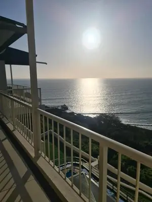 a view of the ocean from the balcony of a house at Bikini Beach Manor in Gordonʼs Bay