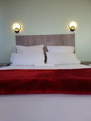 a large bed with a red blanket and two pillows at Ojong's Guesthouse Kraaifontein - Eikendel in Cape Town
