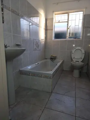 a bathroom with a tub and a toilet and a sink at Ojong's Guesthouse Kraaifontein - Eikendel in Cape Town