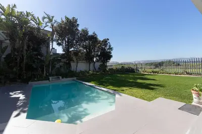 a swimming pool in the backyard of a house at Sunset Spring Villa in Cape Town