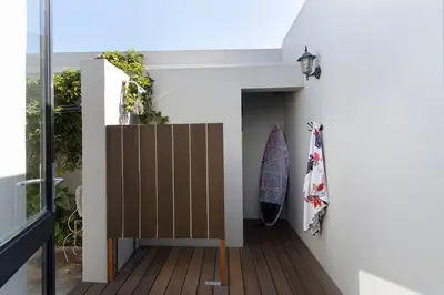 a surfboard leaning against a wall next to a house at Sunset Spring Villa in Cape Town