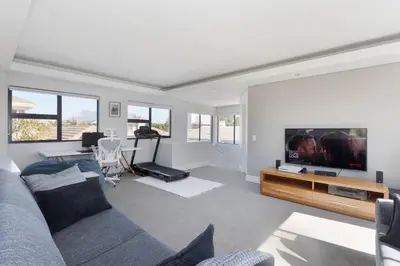 a living room with a couch and a flat screen tv at Sunset Spring Villa in Cape Town
