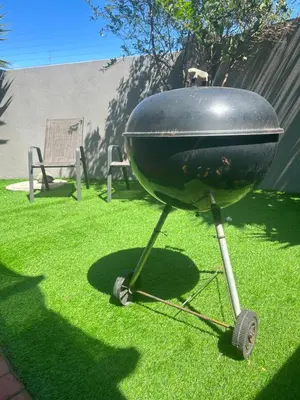 a grill sitting on the grass in a yard at The Great escape 5 mins away from Blouberg Beach in Cape Town