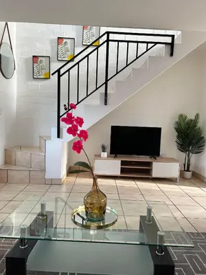 a living room with a tv and a glass table at The Great escape 5 mins away from Blouberg Beach in Cape Town
