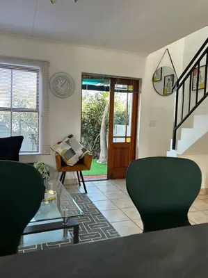 a living room with a couch and a table and chairs at The Great escape 5 mins away from Blouberg Beach in Cape Town