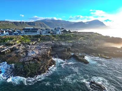 an aerial view of a rocky coastline with houses and the ocean at The W-Collection Esplanade Hermanus in Hermanus