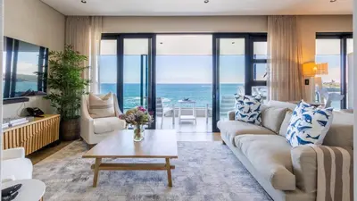 a living room with a couch and a table at The W-Collection Esplanade Hermanus in Hermanus
