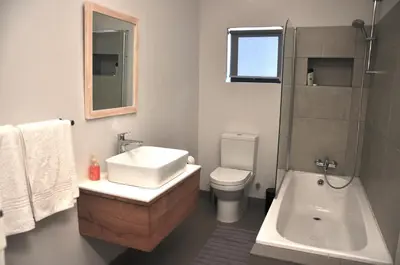 a bathroom with a sink and a toilet and a shower at Blueberry Hill Cottages in Franschhoek