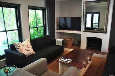 a living room with a couch and a table at Blueberry Hill Cottages in Franschhoek