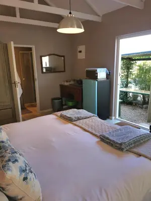 a bedroom with a large white bed with a window at 30 Oak Street in Greyton