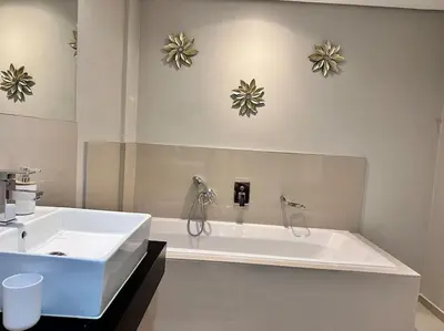 a white bathroom with a tub and a sink at Modern 3 Bed Apartment Blouberg in Cape Town
