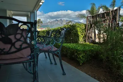 a bench on a porch with a view of the mountains at Monte Vidéo Guesthouse in Wellington