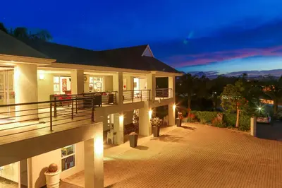 a large house with a balcony at night at Monte Vidéo Guesthouse in Wellington