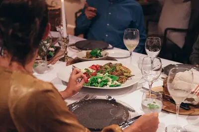 a woman sitting at a table with a plate of food at La Clé Village in Franschhoek