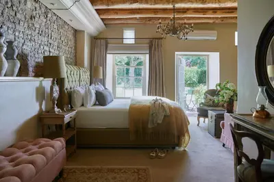 a bedroom with a bed and a large window at La Clé Village in Franschhoek