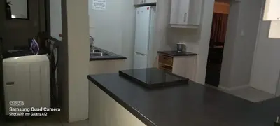 a kitchen with a black counter top and a refrigerator at GALAXY BOSTON BELLVILLE in Cape Town