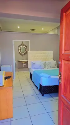 a bedroom with a bed and a mirror on the wall at GALAXY BOSTON BELLVILLE in Cape Town