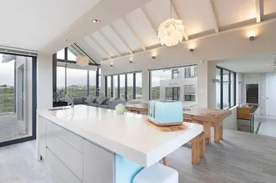 a kitchen and living room with a white counter top at Sunset Village Atlantic Villa in Cape Town