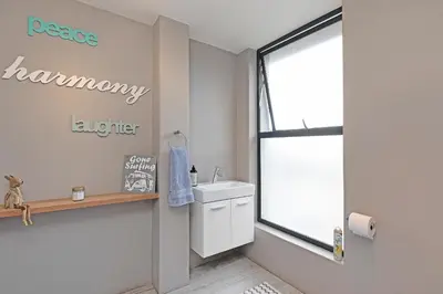 a bathroom with a sink and a window at Sunset Village Atlantic Villa in Cape Town