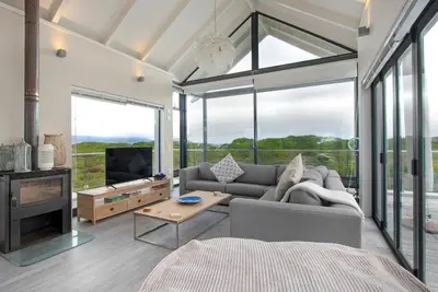 a living room with a couch and a tv at Sunset Village Atlantic Villa in Cape Town