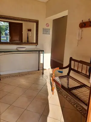 a room with a bed and a mirror and a tile floor at Ringwood Villa in Cape Town