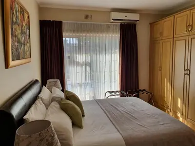 a bedroom with a large bed and a window at Ringwood Villa in Cape Town