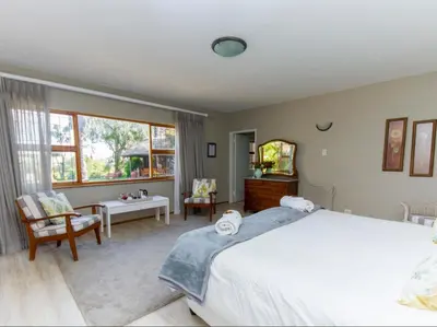a bedroom with a large bed and a table and chairs at Villa Vista in Somerset West