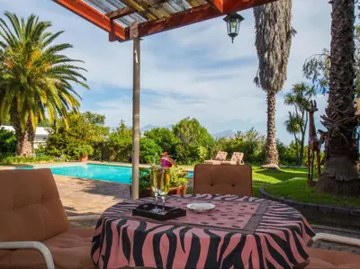 a table with a glass of wine on a patio at Villa Vista in Somerset West