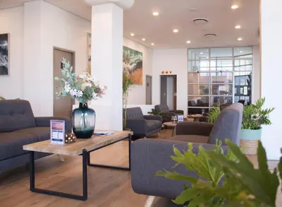 a lobby with couches and a vase of flowers on a table at Ocean Breeze Hotel in Strand