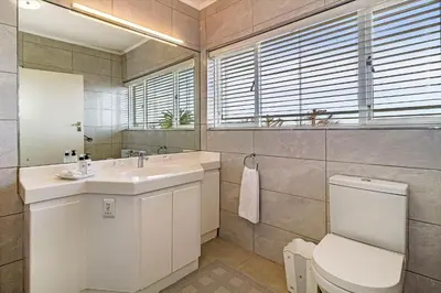 a bathroom with a sink and a toilet and a mirror at Majorca House in Somerset West
