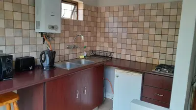 a small kitchen with a sink and a refrigerator at Mooring House in Somerset West