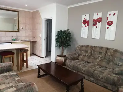 a living room with a couch and a table at Mooring House in Somerset West
